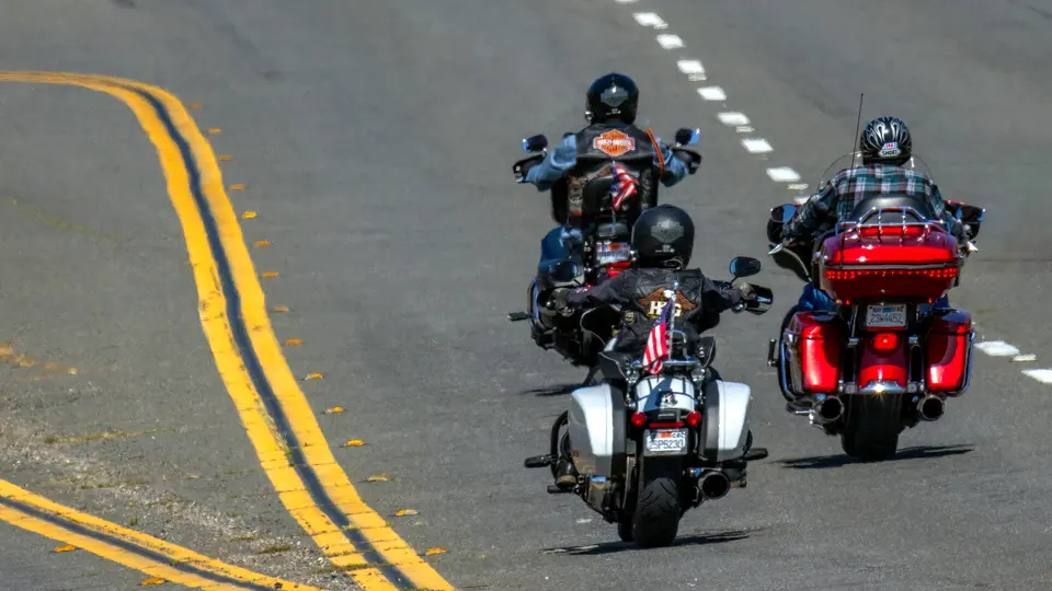 Motorcyclists riding together on a road with double yellow lines